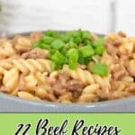 A bowl of creamy pasta with ground beef, topped with chopped green onions, sits in front of text reading "22 Beef Recipes That Hit Like a Flavor Bomb.