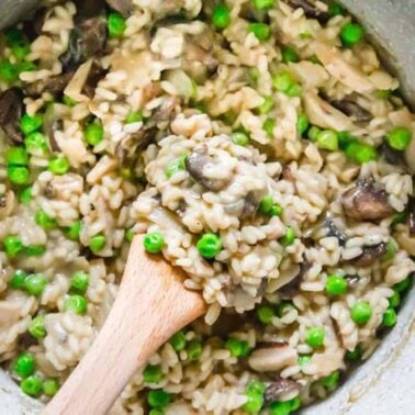 A pot of mushroom and pea risotto with a wooden spoon stirring the creamy rice mixture—perfect for comfort dinners.