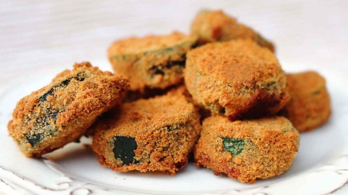 A plate with several breaded and baked zucchini slices arranged in a small pile—perfect for those seeking tasty dairy free recipes.