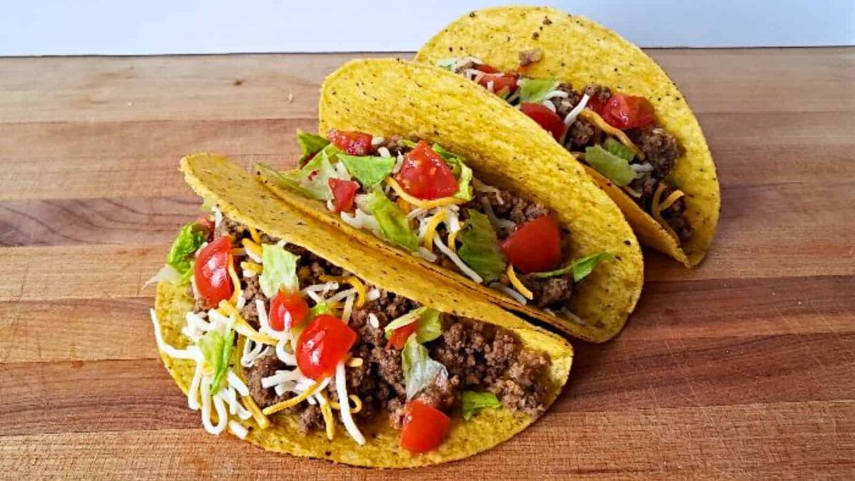 Three hard shell tacos filled with ground beef, shredded cheese, lettuce, and diced tomatoes deliver bold flavor—perfect for easy dinners.