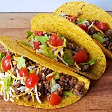 Three hard shell tacos filled with ground beef, shredded cheese, lettuce, and diced tomatoes deliver bold flavor—perfect for easy dinners.