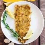 A plate with a breaded chicken breast garnished with rosemary, lemon wedges, and garlic cloves, promoting "10 Rosemary Recipes" with bold lettering at the top.