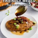 A hand spoons sauce over a seasoned chicken breast garnished with green onions on a white plate, with a salad and skillet in the background. Text reads: "12 Budget Friendly Meals.