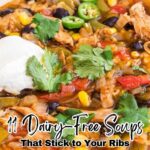 A bowl of soup with chicken, beans, corn, tomatoes, jalapeño slices, cilantro, and a dollop of dairy-free topping. Text reads: "11 Hearty Soups That Stick to Your Ribs—All Delicious Dairy-Free Recipes.