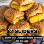 A plate of breakfast sliders made with scrambled eggs, bacon, and cheese on seasoned buns, garnished with chopped herbs, served with grapes and berries.