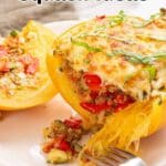 A baked spaghetti squash half filled with a mixture of vegetables and cheese is served on a plate with a fork. Text reads "13 Spaghetti Squash Ideas.