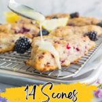 A scone with berries on a cooling rack is drizzled with icing, while blackberries and lemon slices sit in the background. Text reads "14 Unique Scones That Go Beyond The Usualโdiscover the best scones and inventive scone recipes.