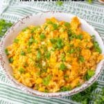 A bowl of enchilada rice topped with chopped green onions, placed on a striped cloth, with text reading "15 Enchilada Recipes That Work For Any Meal.