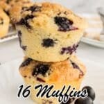 Two blueberry muffins stacked on a white plate with more muffins in the background, and text overlay that reads, "16 Muffins That Don’t Last Till Morning.