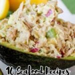 A close-up of seafood salad served in an avocado half, with the text "16 Seafood Recipes That Feel Like a Mini Vacation" at the bottom.