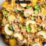 A bowl of fried rice with chicken, peas, pineapple, green onions, and cashews. Text overlay reads "17 Fried Rice Recipes That Never Get Old.