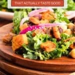 A close-up of a kale salad with roasted sweet potatoes, red onions, chickpeas, and leafy greens on a wooden plate, overlaid with text promoting kale recipes.