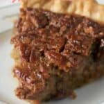 A close-up of a slice of pecan pie on a plate, with text reading “18 Pecan Pie Treats That Combine Comfort and Indulgence.”.