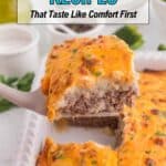 A spatula lifts a serving of cheesy casserole with ground beef and mashed potatoes from a white baking dish. Text overlay reads "19 Casserole Recipes That Taste Like Comfort First.