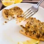 A fork cuts into a seasoned, baked fish fillet on a wooden plate, with lemon wedges nearby. Text reads: "20 Seafood Recipes That Bring the Ocean to the Table. Southern Food and Fun.