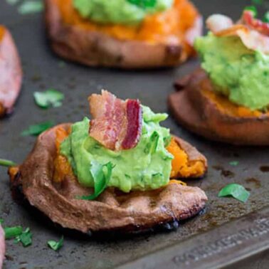 Baked sweet potato rounds topped with mashed avocado, bacon pieces, and chopped cilantro make a flavorful addition to your favorite bacon dishes.