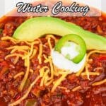 A bowl of chili topped with shredded cheese, a slice of avocado, sour cream, and a jalapeรฑo slice, with text promoting winter meals.