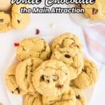 A plate and bowl of white chocolate cookies with cranberries, surrounded by scattered cookies and crumbs, with text promoting white chocolate recipes.