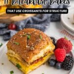 A breakfast bake made with croissants, egg, and cheese is served on a plate with assorted berries; text reads "11 Breakfast Bakes That Use Croissants for Structure.