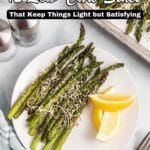 A plate of roasted asparagus topped with grated cheese and served with lemon wedges, next to a baking tray of more asparagus. Text overlay reads "12 Low-Carb Sides That Keep Things Light but Satisfying.