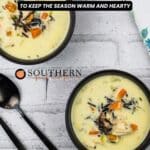 Two black bowls of creamy soup with vegetables and wild rice on a white surface, accompanied by two black spoons and a white napkin with a blue floral pattern. Text reads "12 Winter Soups.