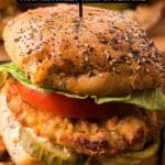 A fried chicken sandwich with lettuce, tomato, pickles, and a seeded bun is shown in close-up with text promoting 13 fried chicken recipes.