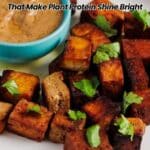 A plate of cooked tofu cubes garnished with herbs, served with a bowl of dipping sauce; text reads "13 Tofu Recipes That Make Plant Protein Shine Bright.