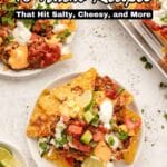 A plate and tray of loaded nachos topped with cheese, sour cream, salsa, and green onions, with lime wedges on the side. Text overlay reads, "18 Nacho Recipes That Hit Salty, Cheesy, and More.