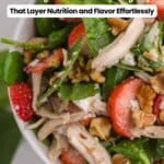 Close-up of a spinach salad with shredded chicken, strawberries, walnuts, and a creamy dressing, accompanied by text promoting 19 spinach recipes.