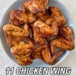 A plate of seasoned, cooked chicken wings on a light-colored surface, with the text โ11 Chicken Wing Recipes That Hit the Spot Every Timeโ and a Southern food logo above.