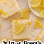 Overhead view of lemon bars topped with icing and lemon slices, with additional lemon slices on a white plate in the background. Text reads: "20 Lemon Desserts That Actually Taste Like Lemon.