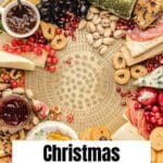 A festive charcuterie board with assorted cheeses, meats, nuts, crackers, fruits, and herbs arranged in a circle on a light tray. Text overlay reads "Christmas Charcuterie Board.
