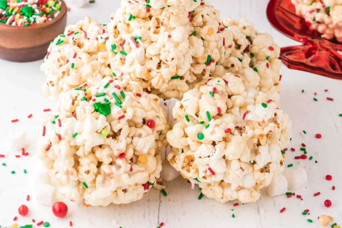 These gooey Christmas popcorn balls with marshmallows, sprinkles, and M&Ms are fun, festive.
