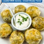 A plate of six golden beef pastry appetizers is arranged around a small bowl of dipping sauce, garnished with chopped chives.