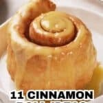 Close-up of a glazed cinnamon roll on a white plate with text overlay reading "11 cinnamon roll ideas swirled with buttery sweetness.