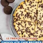 Overhead view of a sliced chocolate chip cheesecake in a glass dish, three chocolate sandwich cookies, and a fork and plate on a white surface.