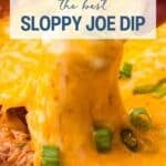 Close-up of cheesy Sloppy Joe dip being scooped, topped with chopped green onions and melted cheese, with a hand holding the scoop.