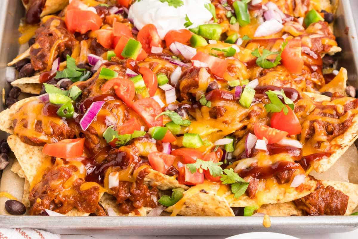 Pulled Pork Nachos: crispy chips, smoky pulled pork, melty cheese, and favorite toppings for a crowd