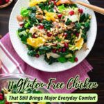 A plate of colorful salad with gluten-free chicken, kale, orange slices, and pomegranate seeds sits on a red-striped napkin beside a bowl of pomegranate arilsโperfect for vibrant everyday meals.