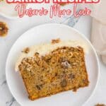 A slice of carrot cake with cream cheese frosting and walnuts sits on a white plate, with a fork, napkin, and extra walnuts nearby on a marble surface.