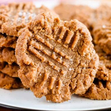 A stack of peanut butter cookies with crisscross fork marks on top, displayed on a white plateโsmart swaps bring big flavor to this treat.