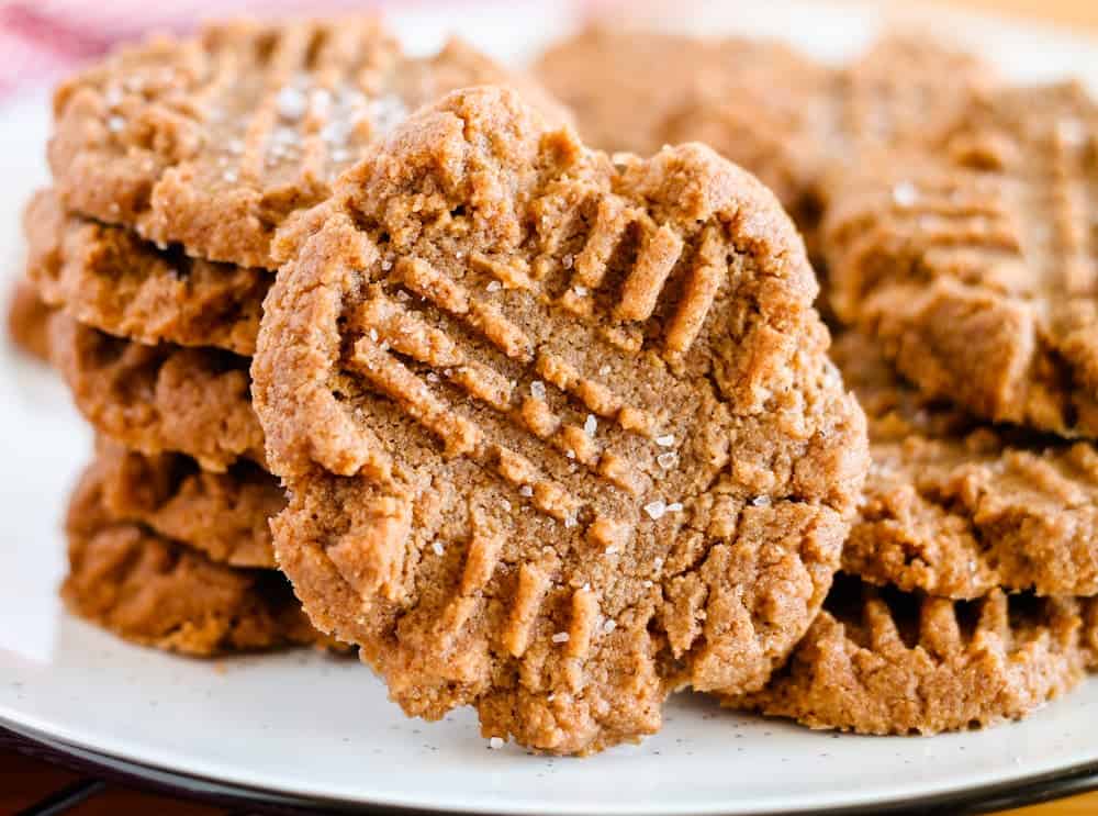 A stack of peanut butter cookies with crisscross fork marks on top, displayed on a white plate—smart swaps bring big flavor to this treat.