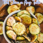 A bowl of fresh, bite-sized baked zucchini chips sits on a wooden table with text promoting delicious vegetarian appetizers.