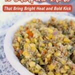A bowl of corn and quinoa salad sits on a white plate, with text overlay that reads "13 Jalapeno Ideas That Bring Bright Heat and Bold Kick.