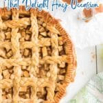 A freshly baked lattice-top apple pie, a classic among spiced apple desserts, sits on a table beside cracked eggs, a cup of brown sugar, and a green-patterned towel.