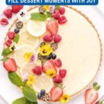 A sweet pie adorned with fresh berries, lemon slices, and edible flowers, partially photographed on a white plate with text promoting delicious pie recipes.