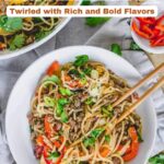 A bowl of noodle stir-fry with ground meat, red bell peppers, and green onions, with chopsticks resting on the bowl and another bowl behind. Text reads "20 Hearty Noodle Recipes"โdiscover bold flavors in these hearty noodle recipes.