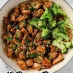 A white pan filled with cooked chicken pieces in a brown sauce, garnished with chopped herbs and broccoli florets. Text overlay reads, "12 Protein Dinners Covered in Sauce With Serious Attitude—perfect for easy dinner recipes.