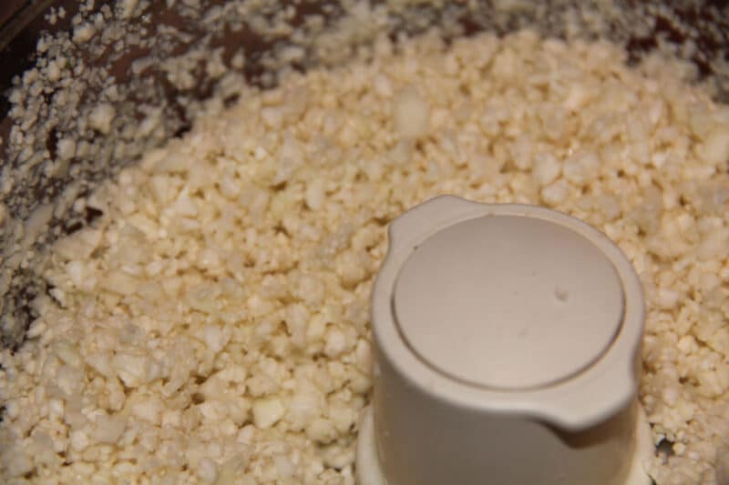 Chopped cauliflower pieces in a food processor.
