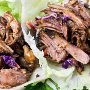 Effortless shredded cooked meat and coleslaw served on large lettuce leaves as wrapsโperfect for dinner and inspired by slow cooker pork recipes.